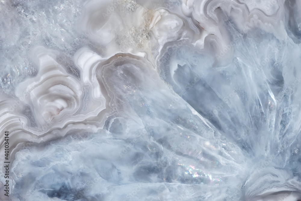 Full-screen close-up texture of light blue-white agate with quartz crystals. Natural stone background. Full-screen close-up texture of light blue-white agate with quartz crystals. Natural stone background.