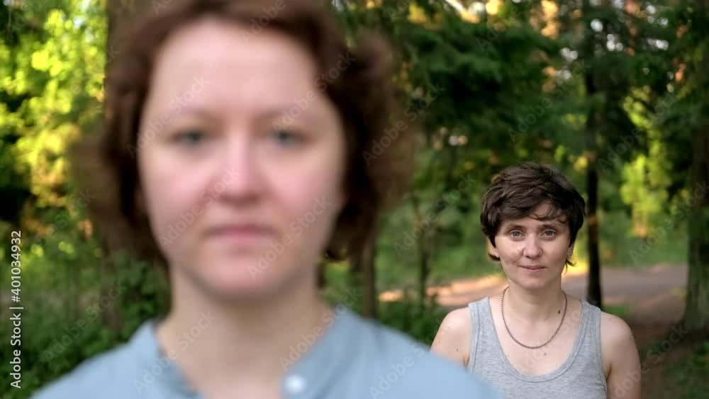 A close up portrait of two young caucasian brunette women outdoors. A lesbian couple. A close up portrait of two young caucasian brunette women outdoors. A lesbian couple.