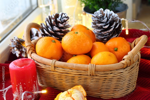 New Year's still life with tangerines in a basket and decorative berries