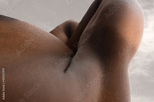 Meadow. Detailed texture of human skin. Close up of young african-american male body surface like landscape with the sky on background. Skincare  bodycare  healthcare  inspiration  fantasy artwork.