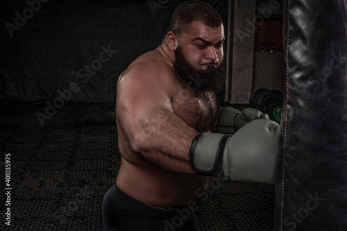 Arab heavyweight boxer practicing punching a punching bag