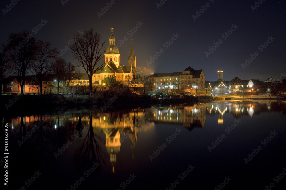 Seligenstadt bei Nacht mit dem Spiegelbild der Basilika und der Häuser im Main