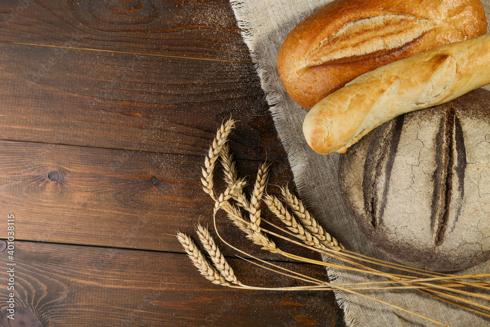 homemade bread and ears of wheat are on wooden rustic background homemade bread and ears of wheat are on wooden rustic background
