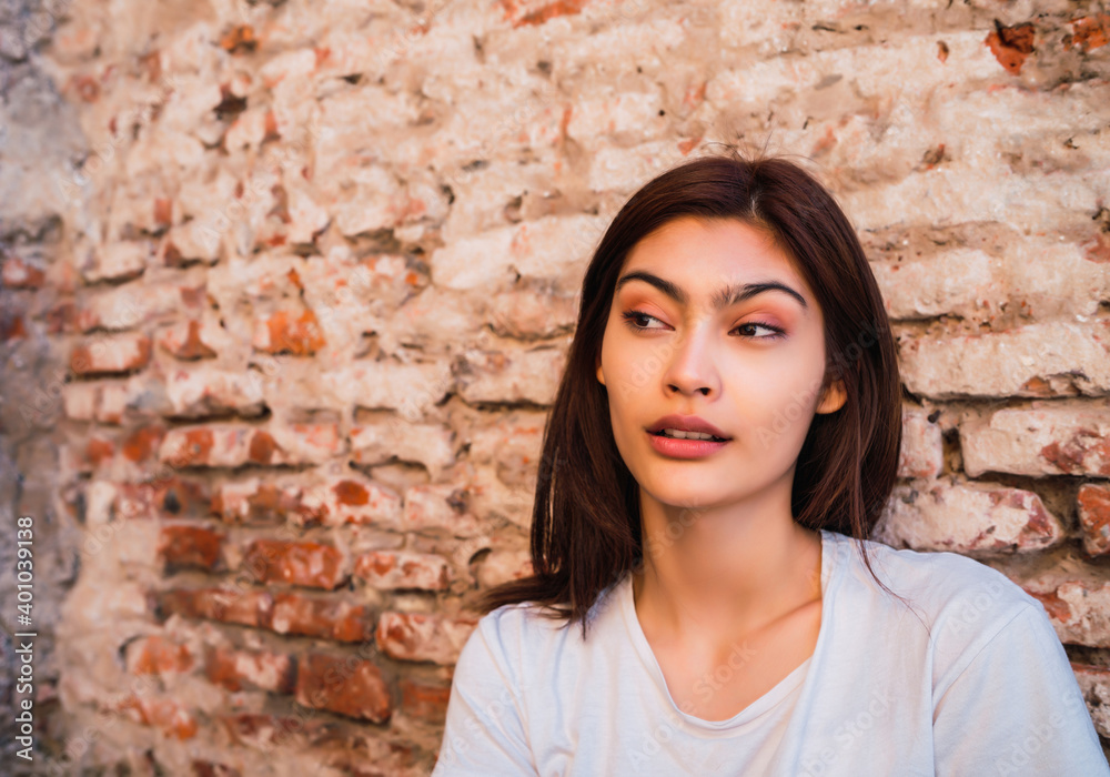 Young latin woman against brick wall. Young latin woman against brick wall.