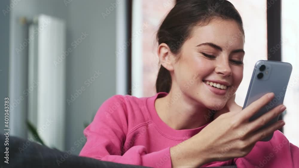 Young happy girl using mobile phone indoors at home Young happy girl using mobile phone indoors at home