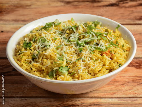 Veg pulao cooked with masala spices, served over a rustic wooden background, selective focus