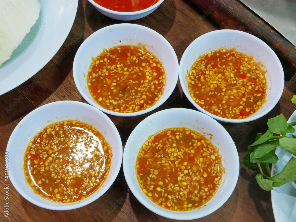 Thai spicy seafood dipping sauce ( Nam Jim Sam Rod ) in small bowls, get prepared on a table and ready to be served Thai spicy seafood dipping sauce ( Nam Jim Sam Rod ) in small bowls, get prepared on a table and ready to be served