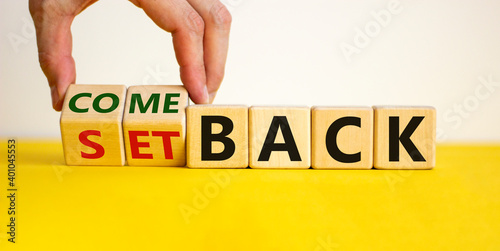 Setback or comeback symbol. Male hand flips wooden cubes and changes the word 'setback' to 'comeback'. Beautiful yellow and white background, copy space. Business and comeback concept. photo