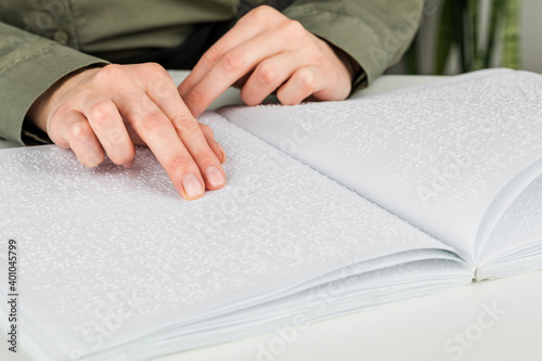 A woman reads a book written in Braille.