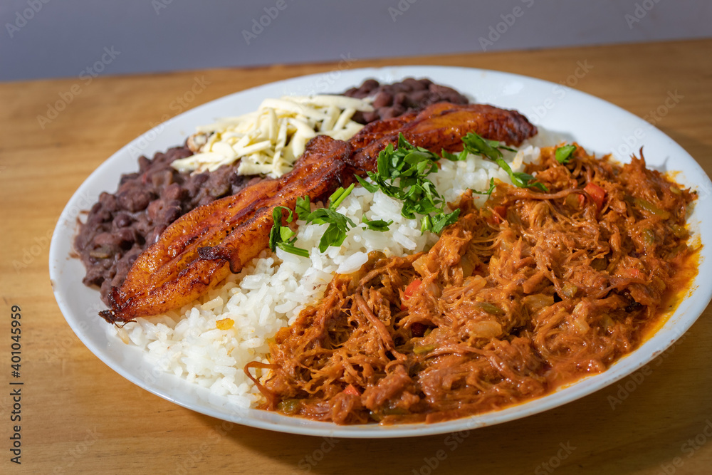 white plate with Venezuelan food, meat, fried plantain, rice, and beans white plate with Venezuelan food, meat, fried plantain, rice, and beans