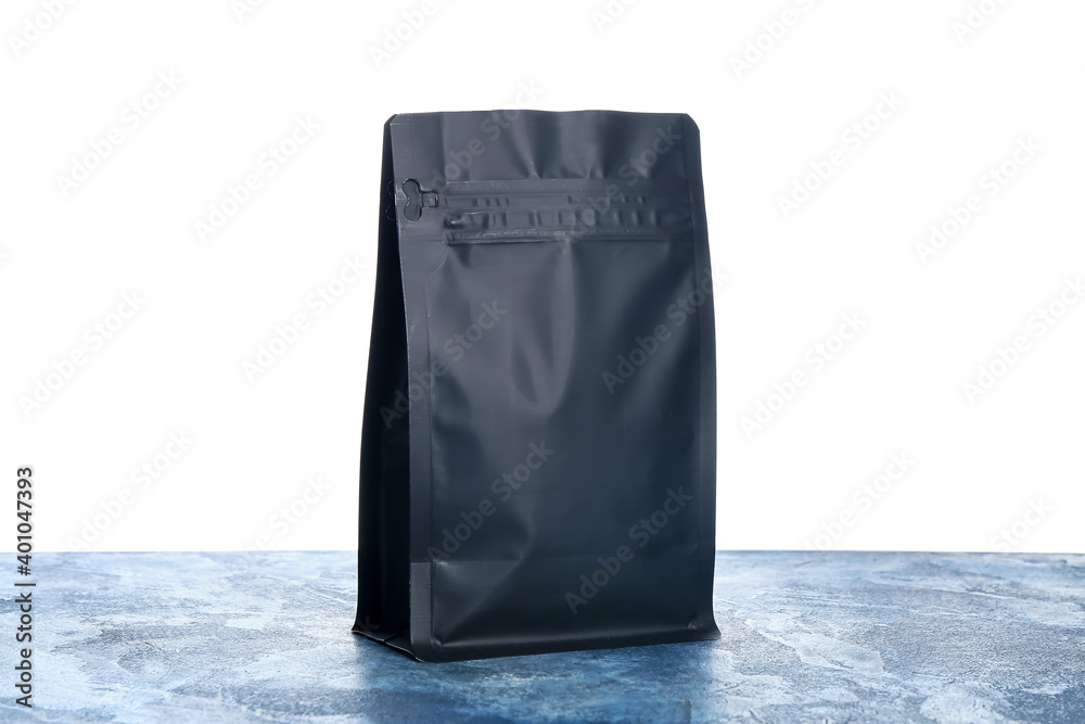 Blank coffee bag on table against white background