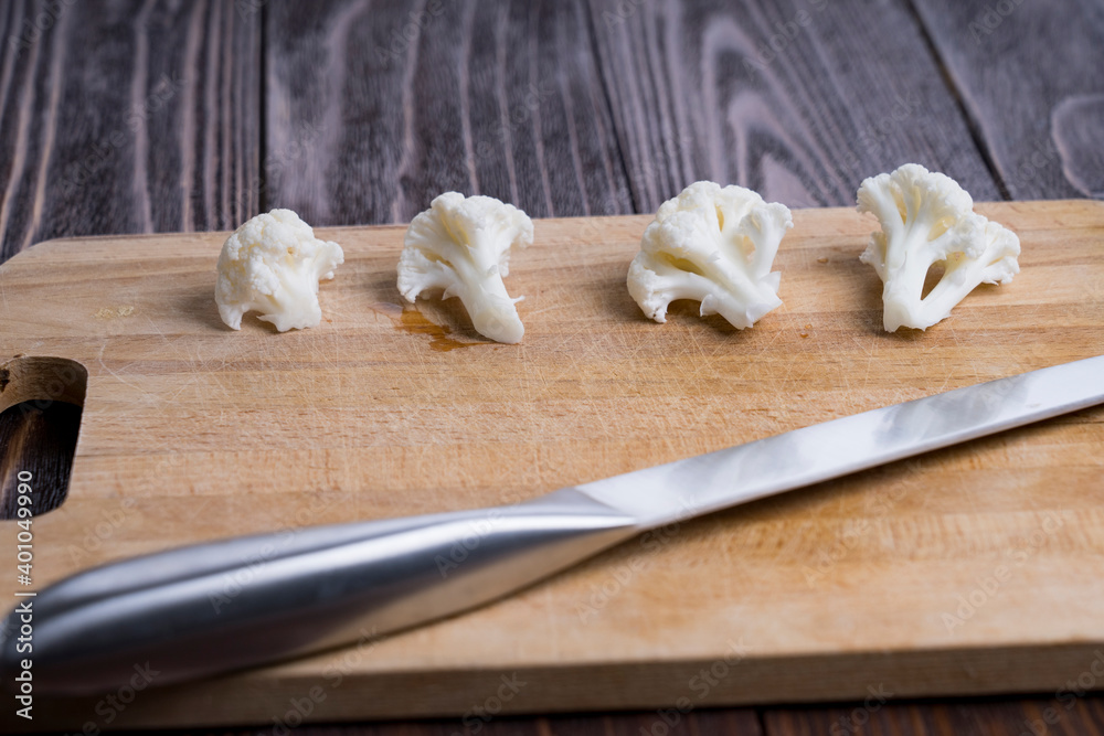 boiled white cauliflower on a Board and a knife, selective focus, tinted image