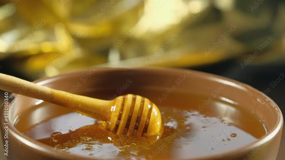 Honey drips, pours from the honey ladle into the plate. Healthy organic honey, natural beekeeping product, healthy food concept. close-up. 4K video recording Honey drips, pours from the honey ladle into the plate. Healthy organic honey, natural beekeeping product, healthy food concept. close-up. 4K video recording