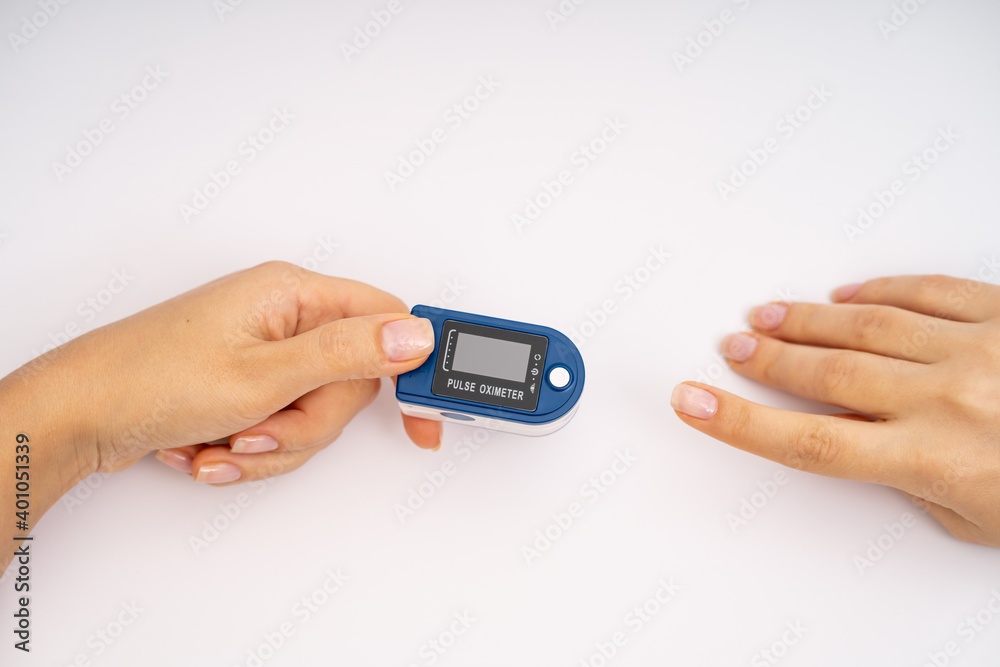 Fingertip Pulse Oximeter on finger. On white background. Device for self health diagnostic
