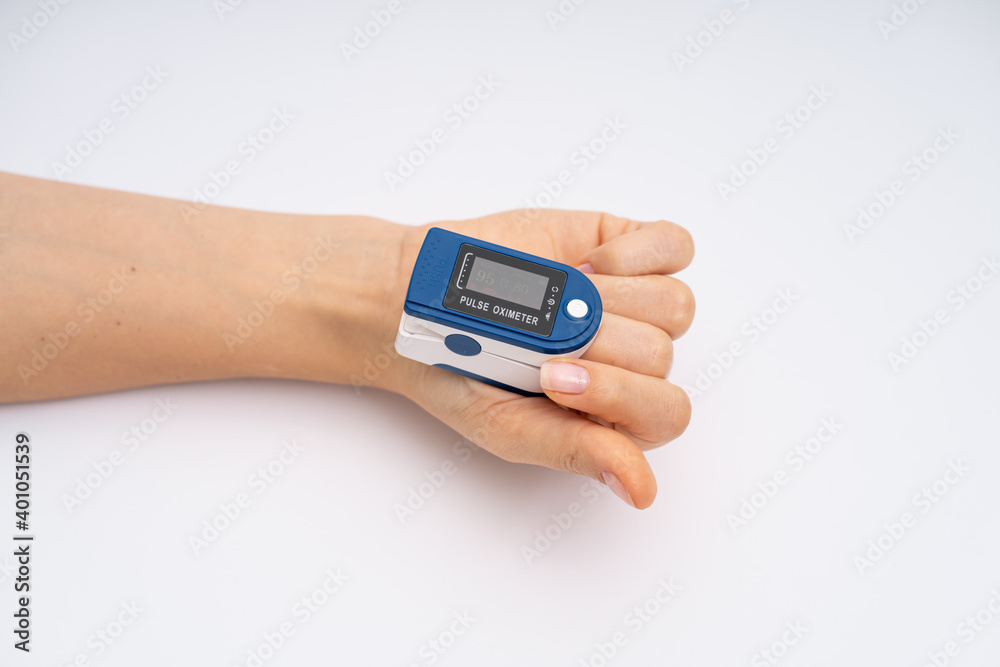 Fingertip Pulse Oximeter on finger. On white background. Device for self health diagnostic Fingertip Pulse Oximeter on finger. On white background. Device for self health diagnostic