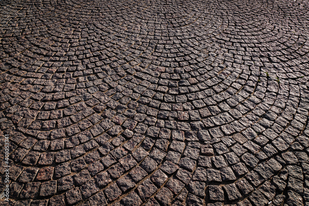 City sidewalk paved with cobblestone, natural stone background