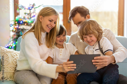 Young family having fun with digital tablet on couch
