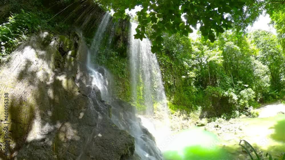 Jungle Waterfall in a tropical forest surrounded by green vegetation. Kawasan Falls in mountain jungle. Bohol, Philippines. Jungle Waterfall in a tropical forest surrounded by green vegetation. Kawasan Falls in mountain jungle. Bohol, Philippines.