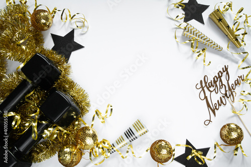 Photography Heavy black dumbbells, golden decorations and party horn blowers for New Year's Eve celebration