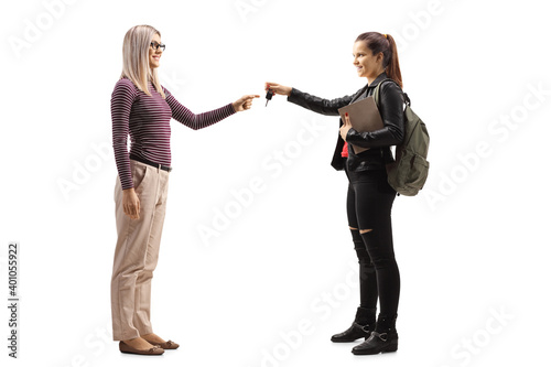 Full length profile shot of a female student returning car keys to a blond woman