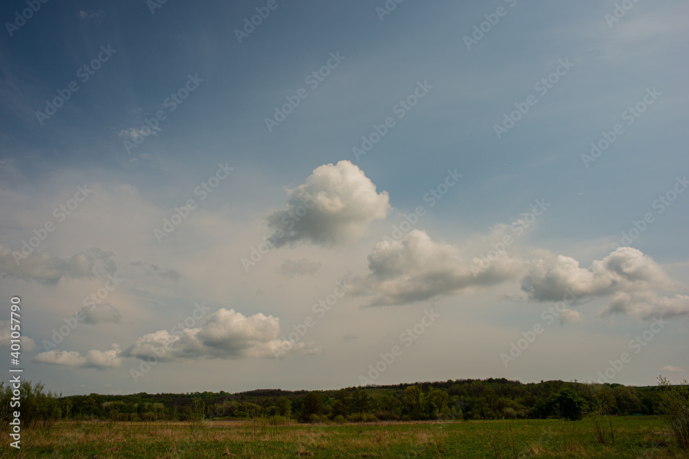 Clouds on blue sky and deciduous forest and meadow. Clouds on blue sky and deciduous forest and meadow.