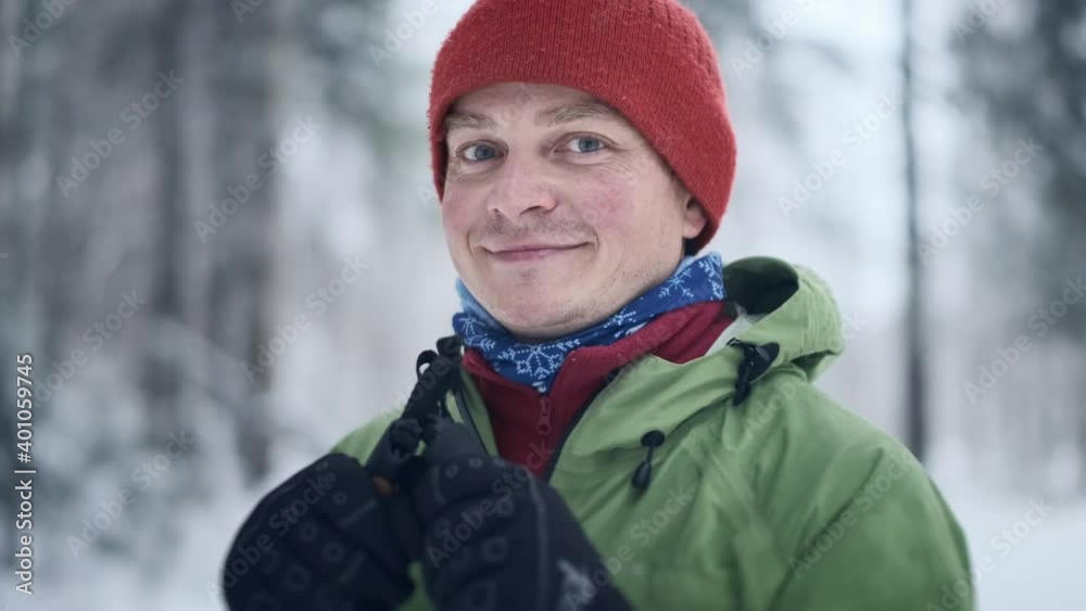 Skier in the forest. Portrait of the young caucasian skier man standing in the forest and looking into the camera Skier in the forest. Portrait of the young caucasian skier man standing in the forest and looking into the camera