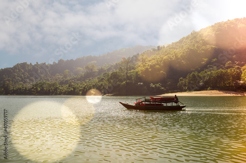 boat moving through narrow river and mountains on a sunny day