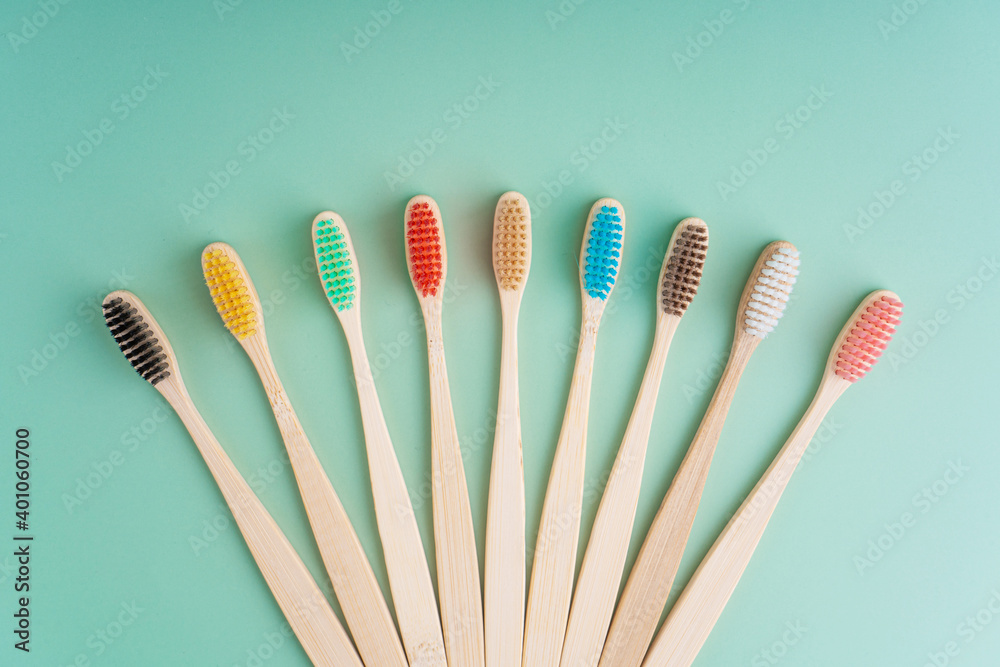 A set of Eco-friendly antibacterial toothbrushes made of bamboo wood on a light green background. Environmental care trends A set of Eco-friendly antibacterial toothbrushes made of bamboo wood on a light green background. Environmental care trends