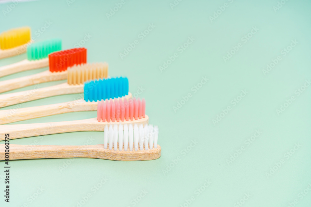 A set of Eco-friendly antibacterial toothbrushes made of bamboo wood on a light green background. Environmental care trends A set of Eco-friendly antibacterial toothbrushes made of bamboo wood on a light green background. Environmental care trends