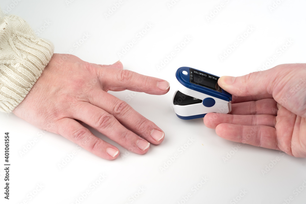 Putting the pulse oximeter on the finger for measurements. Copy space.