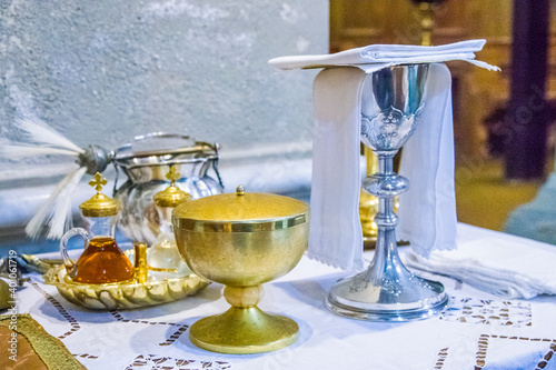 chalice for wine, blood of christ, and ciborium with host, body of christ, and ampoules with wine and water for consecration photo