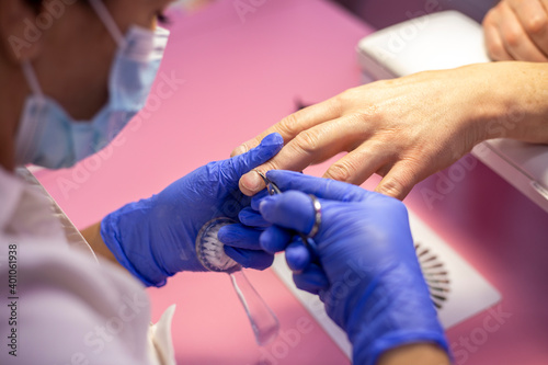 Manicurist cuts the cuticle on a man's hand with scissors. Men's manicure in salon