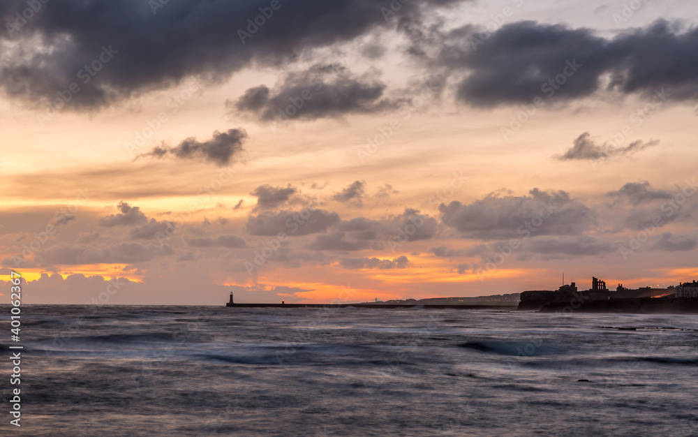 Sunrise at a chilly Cullercoats Bay in the north east of England, with Tynemouth Pier and the lighthouse in the distance