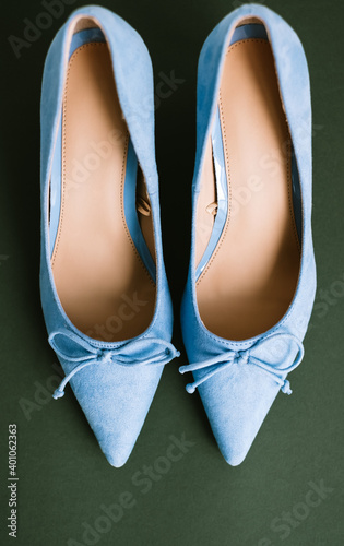 Blue womens shoes with heels on green background. 