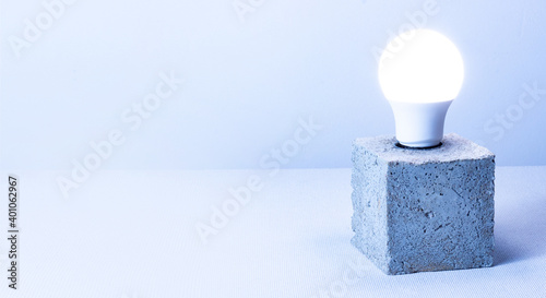 Bild auf Leinwand A luminaire with a lamp emits light. Gray concrete stand