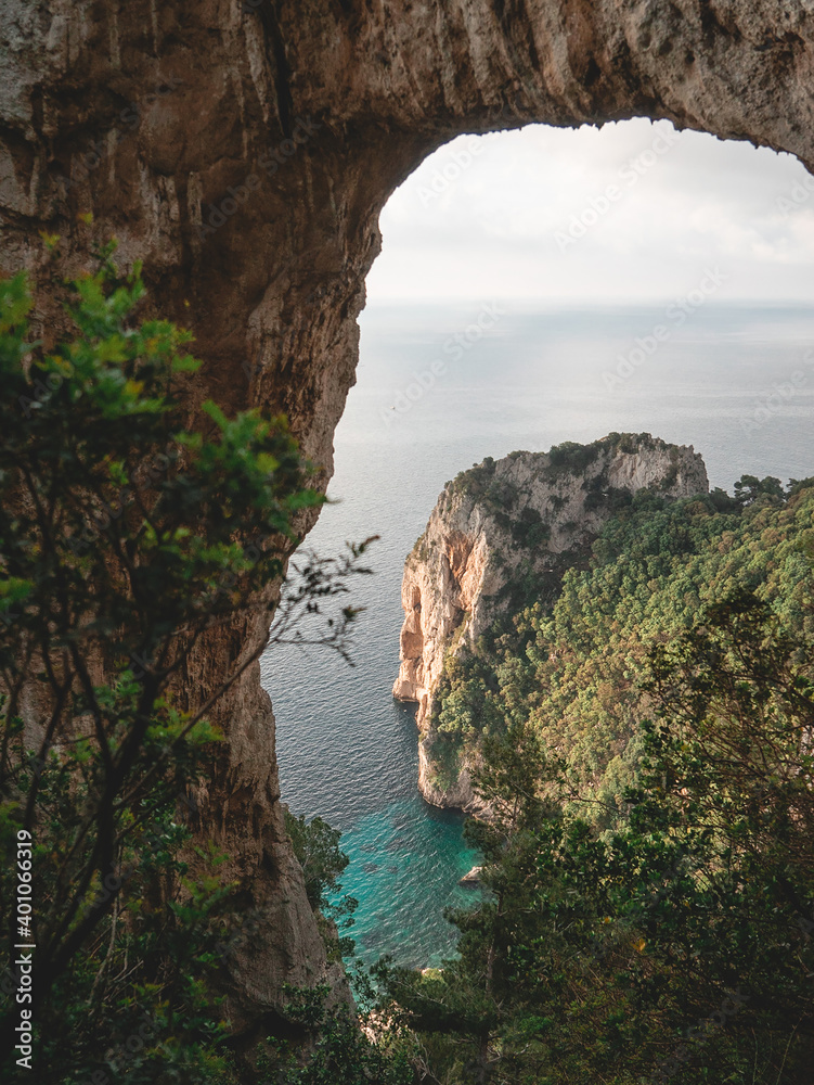 Natural arch on the coast with crystal clear water below.