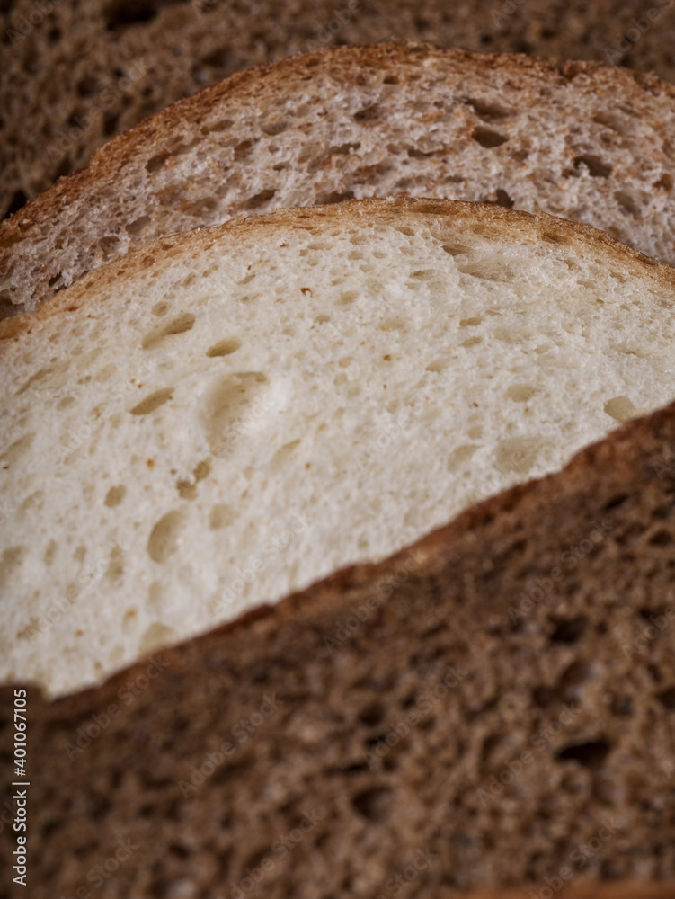 sliced loaf of bread. white and black bread. bread on white wood background 