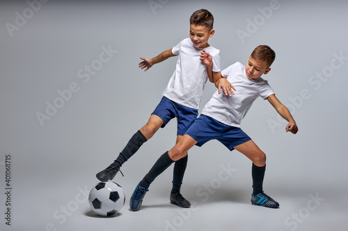 two soccer players interfere with each other, compete. studio portrait of young football players
