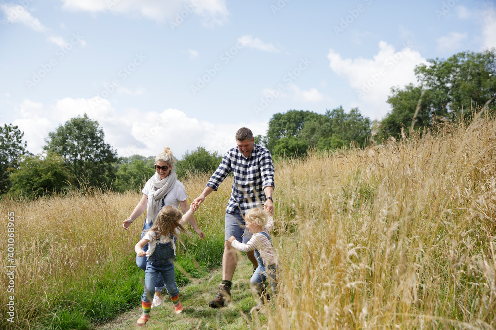 Happy family running in sunny rural field Happy family running in sunny rural field