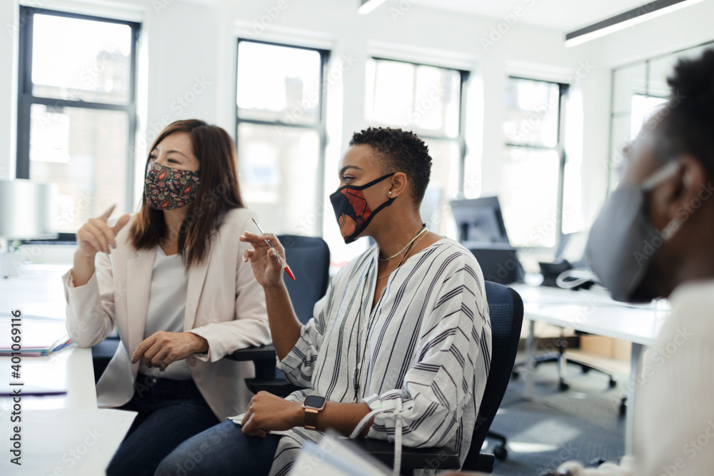 Business people in face masks meeting in office Business people in face masks meeting in office