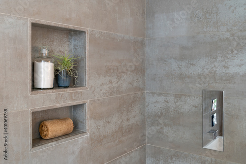 Foto Detail of tile and stone shower inset with bath salts, loofah, and plant decor