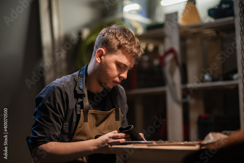 a hereditary shoemaker makes shoes from leather in the family workshop