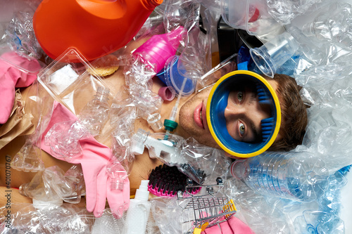 portrait of guy lying around plastic rubbish trash, irresponsibility and carelessness of people to the environment concept photo