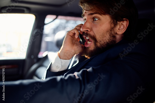 a man in a suit in a car talking on the phone an official passenger © SHOTPRIME STUDIO