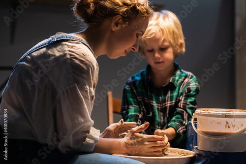 a pottery lesson at an art school is taught by a young girl a potter for a cute child