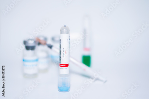 Testing for presence of coronavirus. Tube containing a swab sample that has tested positive for COVID-19. A single bottle vial of Covid-19 coronavirus vaccine in a research medical lab. 