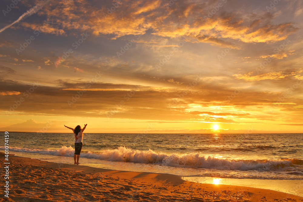 Happy woman on the sunset beach