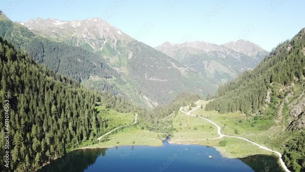 Drone shot of an Alpine, navy blue colored lake in a valley in Schladming region, Austria. The lake is surrounded by high mountains. The mountains reflect in the calm surface of the lake. Early spring Drone shot of an Alpine, navy blue colored lake in a valley in Schladming region, Austria. The lake is surrounded by high mountains. The mountains reflect in the calm surface of the lake. Early spring