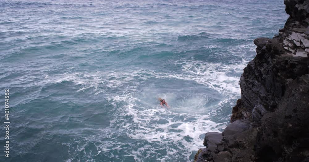 Caucasian woman swimming in ocean near cliff on Maui