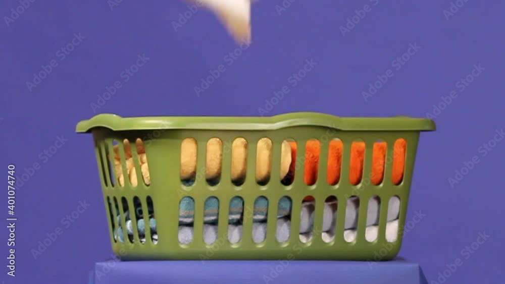 Folded towels falling into laundry basket